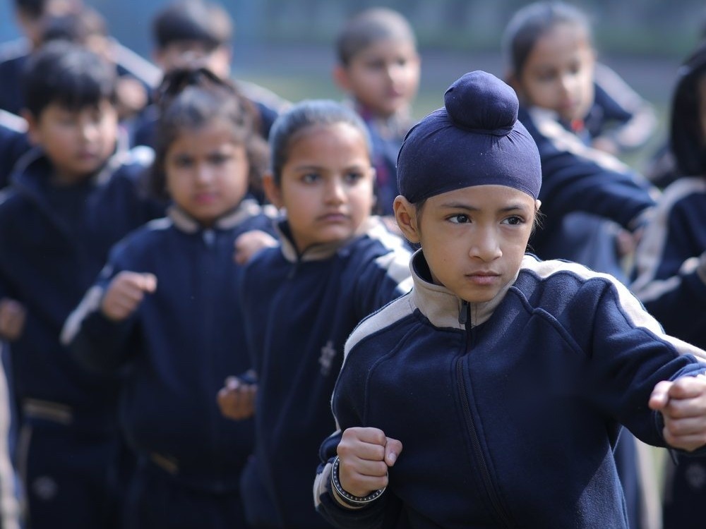 A student holds a focused martial arts stance during a house sports session at Infinia World School